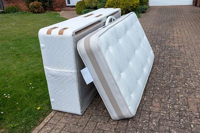 a mattress being loaded onto a truck for removal